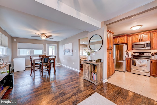 67 Neptune Ln, Levittown, PA 19054 - kitchen with stainless steel appliances, a ceiling fan, brown cabinetry, light wood-type flooring, and light countertops
