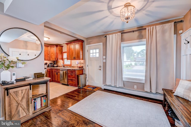 67 Neptune Ln, Levittown, PA 19054 - kitchen featuring baseboard heating, dishwasher, light wood finished floors, brown cabinetry, and light countertops