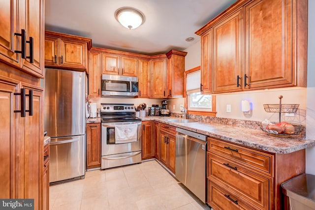 67 Neptune Ln, Levittown, PA 19054 - kitchen with appliances with stainless steel finishes, brown cabinetry, light tile patterned floors, and light stone counters