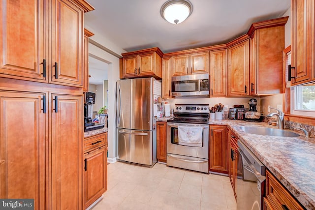 67 Neptune Ln, Levittown, PA 19054 - kitchen featuring stainless steel appliances, brown cabinetry, and light tile patterned flooring