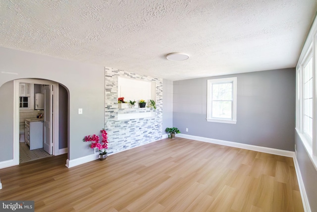 6 Carroll Rd, Catonsville, MD 21228 - empty room with arched walkways, wood finished floors, and a textured ceiling