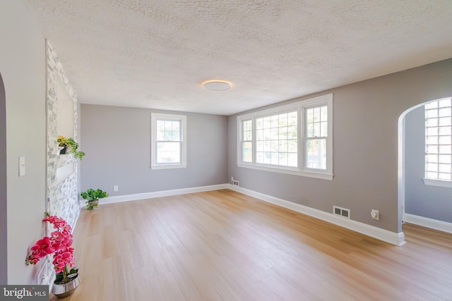 6 Carroll Rd, Catonsville, MD 21228 - spare room with arched walkways, light wood finished floors, a textured ceiling, and healthy amount of natural light