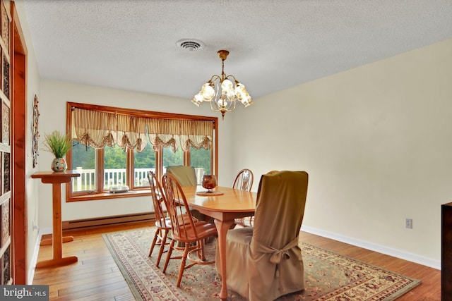 20412 Holt Cir, Hagerstown, MD 21742 - dining area featuring a baseboard heating unit, a chandelier, wood finished floors, and a textured ceiling