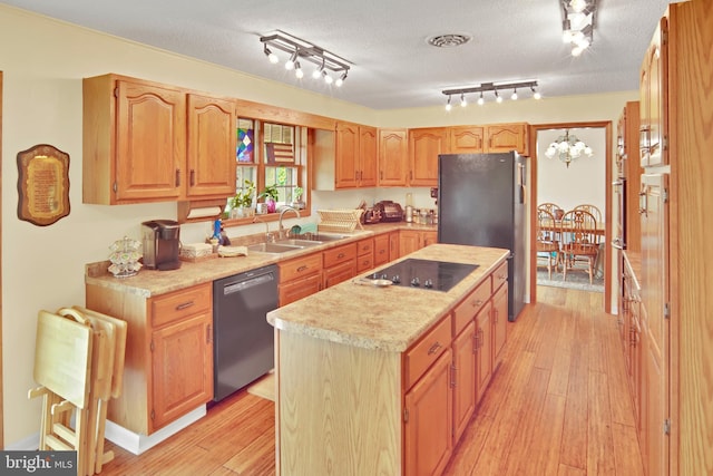 20412 Holt Cir, Hagerstown, MD 21742 - kitchen featuring dishwashing machine, black electric stovetop, freestanding refrigerator, a center island, and light wood-style floors