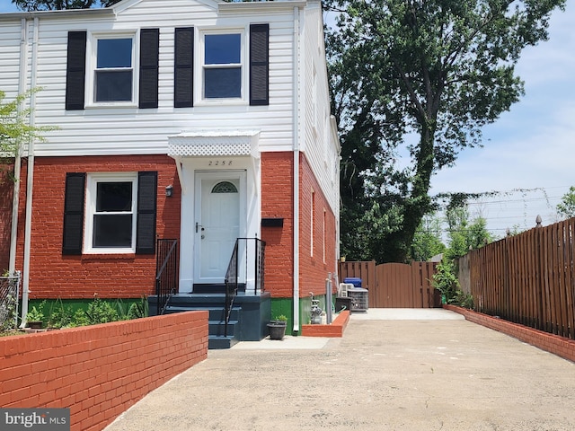 2258 Arlington Ter, Alexandria, VA 22303 - view of front facade featuring brick siding, a gate, and concrete driveway