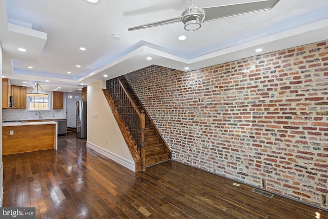 244 N Rose St, Baltimore, MD 21224 - unfurnished living room with a tray ceiling, stairs, dark wood finished floors, recessed lighting, and a ceiling fan