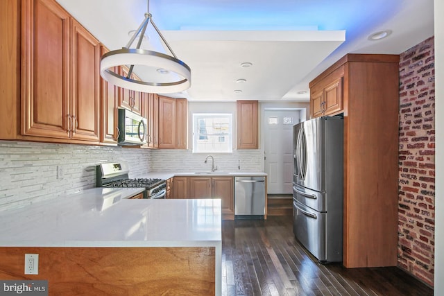 244 N Rose St, Baltimore, MD 21224 - kitchen featuring stainless steel appliances, dark wood-style flooring, light countertops, decorative backsplash, and a peninsula