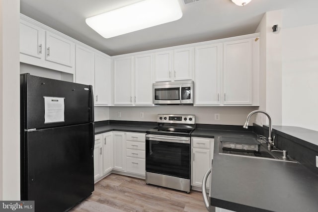 19278 Harlow Sq, Leesburg, VA 20176 - kitchen with appliances with stainless steel finishes, white cabinetry, dark countertops, and light wood-style floors