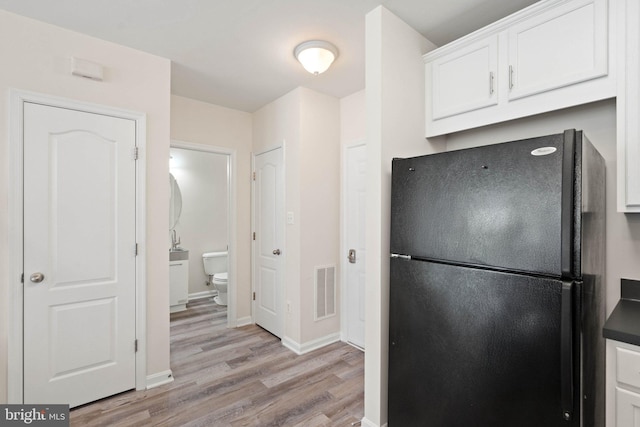19278 Harlow Sq, Leesburg, VA 20176 - kitchen with freestanding refrigerator, light wood-style flooring, white cabinetry, and dark countertops