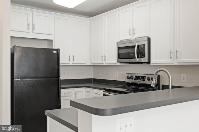 19278 Harlow Sq, Leesburg, VA 20176 - kitchen featuring appliances with stainless steel finishes, white cabinetry, a peninsula, and dark countertops
