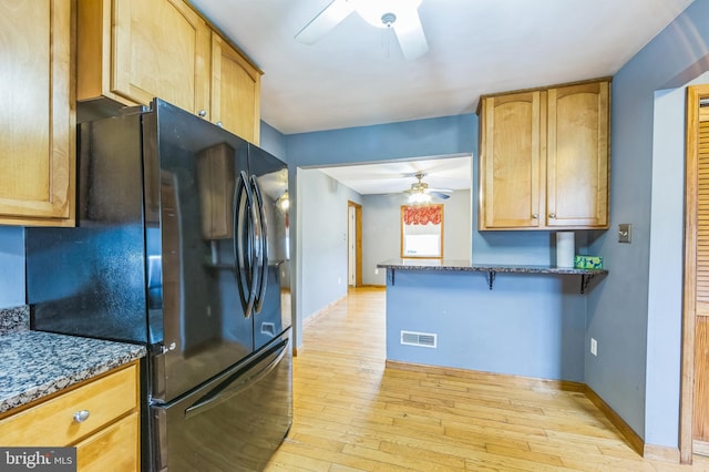 739 Brooke Cir, Morton, PA 19070 - kitchen featuring ceiling fan, freestanding refrigerator, light wood-type flooring, and dark stone counters