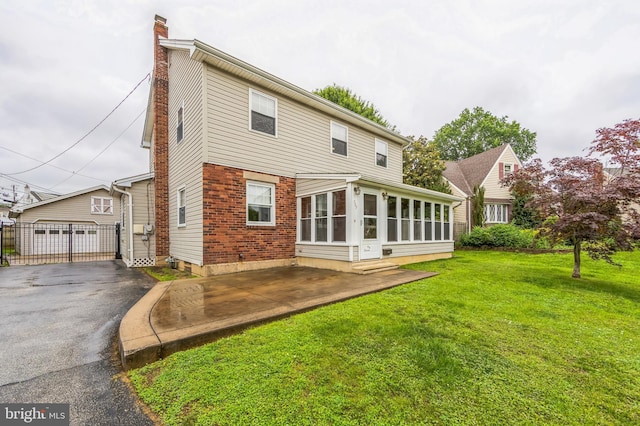 739 Brooke Cir, Morton, PA 19070 - back of house featuring a chimney, a sunroom, a yard, a patio, and brick siding