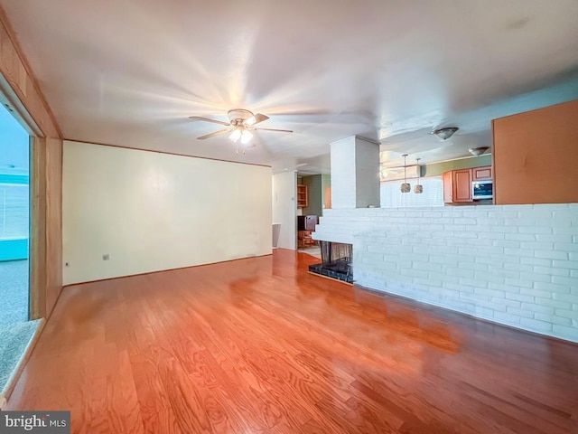 237 Lakeside Dr Unit N, Levittown, PA 19054 - unfurnished living room with light wood-style flooring, ceiling fan, and a fireplace