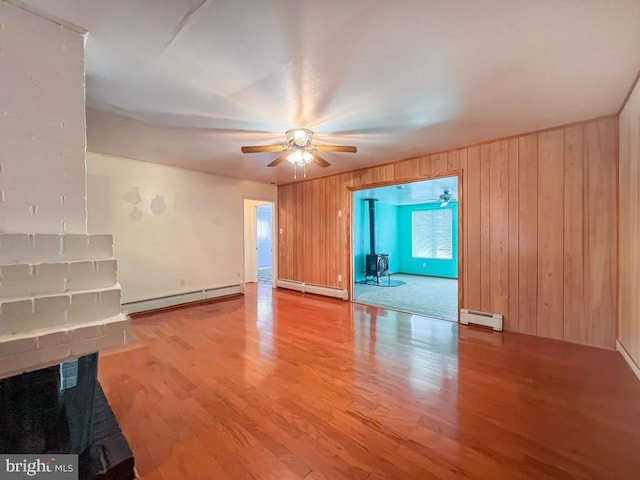 237 Lakeside Dr Unit N, Levittown, PA 19054 - unfurnished living room featuring a baseboard heating unit, a ceiling fan, wood finished floors, and wood walls