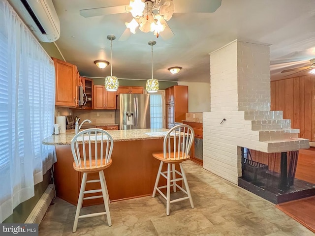 237 Lakeside Dr Unit N, Levittown, PA 19054 - kitchen featuring appliances with stainless steel finishes, ceiling fan, a wall unit AC, a peninsula, and brown cabinetry