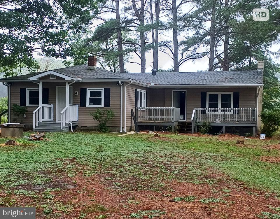 1171 Jones Creek Rd, Warsaw, VA 22572 - ranch-style house featuring covered porch, a chimney, a front lawn, and roof with shingles