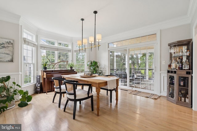 18416 Mill Run Ct, Leesburg, VA 20176 - dining space featuring ornamental molding, healthy amount of natural light, a dry bar, light wood-style flooring, and a chandelier