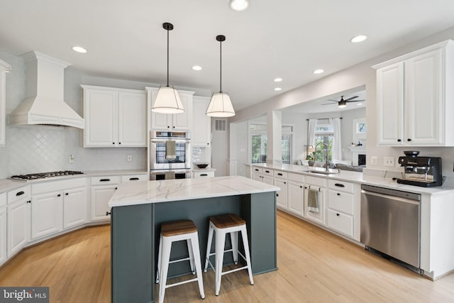 18416 Mill Run Ct, Leesburg, VA 20176 - kitchen with appliances with stainless steel finishes, premium range hood, a kitchen island, white cabinetry, and recessed lighting