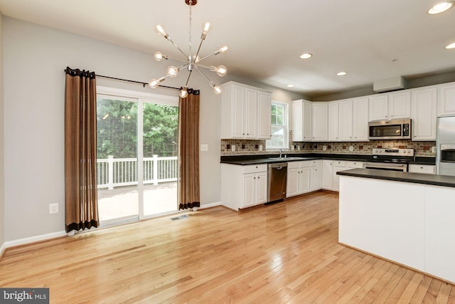 7041 Water Oak Rd Unit 42, Elkridge, MD 21075 - kitchen featuring stainless steel appliances, dark countertops, a chandelier, backsplash, and white cabinetry