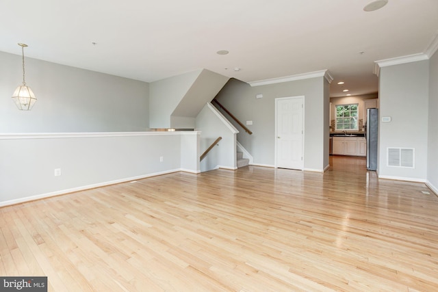 7041 Water Oak Rd Unit 42, Elkridge, MD 21075 - unfurnished living room featuring light wood finished floors, ornamental molding, and stairway