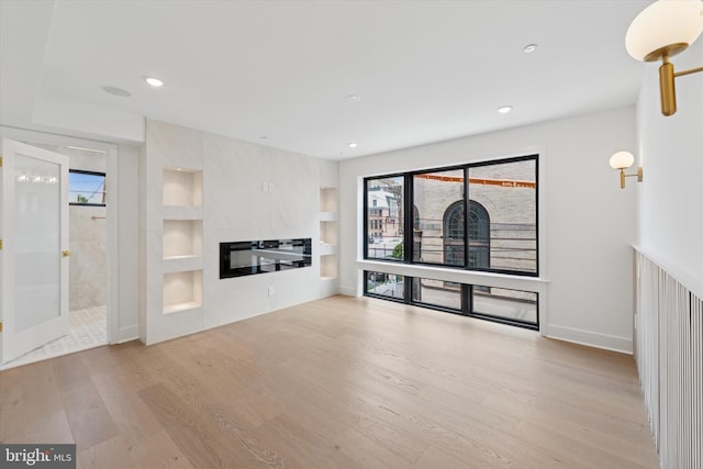 919 S 11th St Unit B, Philadelphia, PA 19147 - unfurnished living room with wood finished floors, built in shelves, recessed lighting, and a glass covered fireplace