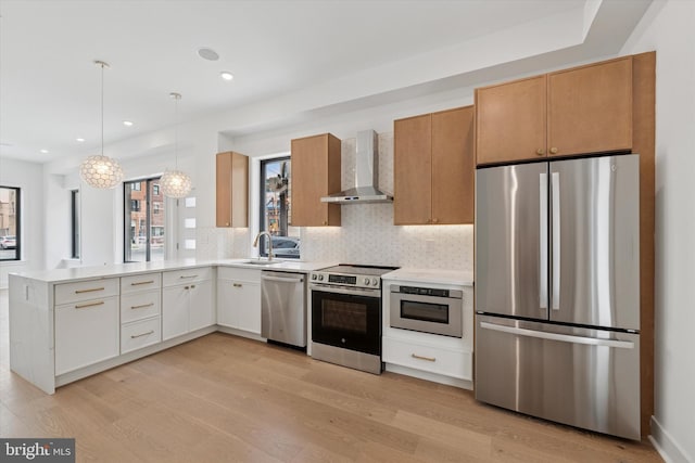 919 S 11th St Unit B, Philadelphia, PA 19147 - kitchen featuring stainless steel appliances, wall chimney range hood, light countertops, decorative backsplash, and light wood finished floors