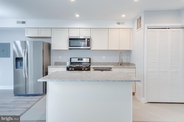 537 Newcomb St SE, Washington, DC 20032 - kitchen with appliances with stainless steel finishes, electric panel, recessed lighting, a kitchen island, and white cabinetry