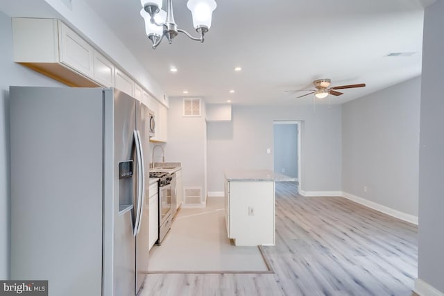 537 Newcomb St SE, Washington, DC 20032 - kitchen featuring stainless steel appliances, white cabinetry, recessed lighting, light wood-style floors, and a chandelier