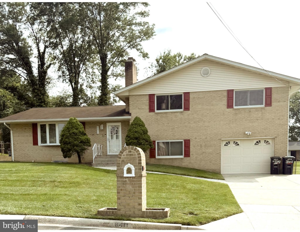 6411 Gifford Ln, Temple Hills, MD 20748 - split level home with a garage, brick siding, a chimney, driveway, and a front lawn