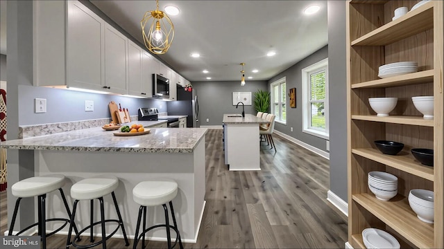 519 Clarks Run Rd, La Plata, MD 20646 - kitchen featuring appliances with stainless steel finishes, open shelves, dark wood finished floors, light stone countertops, and white cabinetry