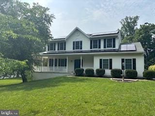 724 Hookers Mill Rd, Abingdon, MD 21009 - view of front of home with roof mounted solar panels, a front yard, and covered porch