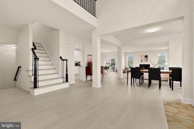 22974 Weybridge Sq, Broadlands, VA 20148 - foyer featuring light wood finished floors, stairs, crown molding, and a towering ceiling