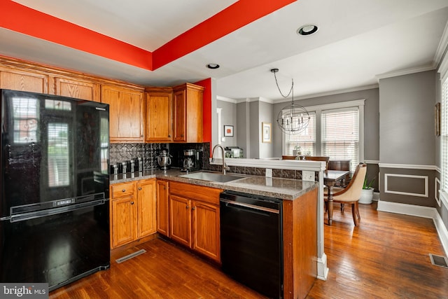227 Ruby St, Lancaster, PA 17603 - kitchen featuring black appliances, brown cabinetry, a peninsula, ornamental molding, and a chandelier