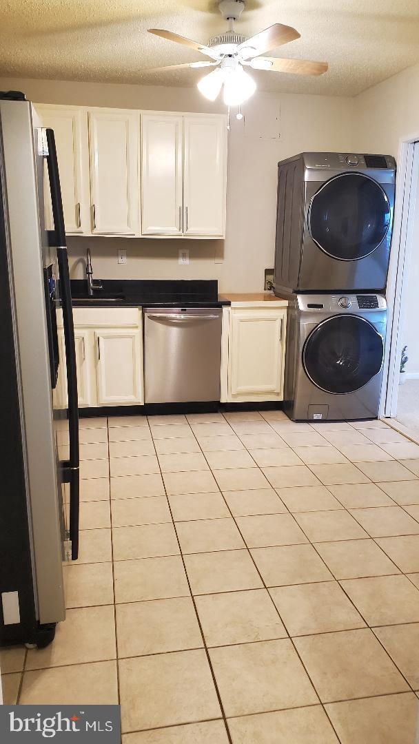 3705 S George Mason Dr Unit 1311, Falls Church, VA 22041 - kitchen with stacked washer / drying machine, appliances with stainless steel finishes, ceiling fan, white cabinetry, and a textured ceiling