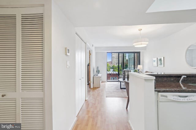 1401 17th St NW Unit 610, Washington, DC 20036 - kitchen featuring white dishwasher, light wood-style flooring, and hanging light fixtures