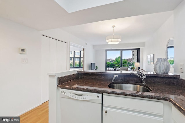 1401 17th St NW Unit 610, Washington, DC 20036 - kitchen with dishwasher, white cabinets, light wood finished floors, dark stone counters, and decorative light fixtures