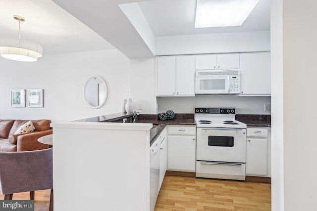 1401 17th St NW Unit 610, Washington, DC 20036 - kitchen with white appliances, dark countertops, white cabinets, open floor plan, and a peninsula