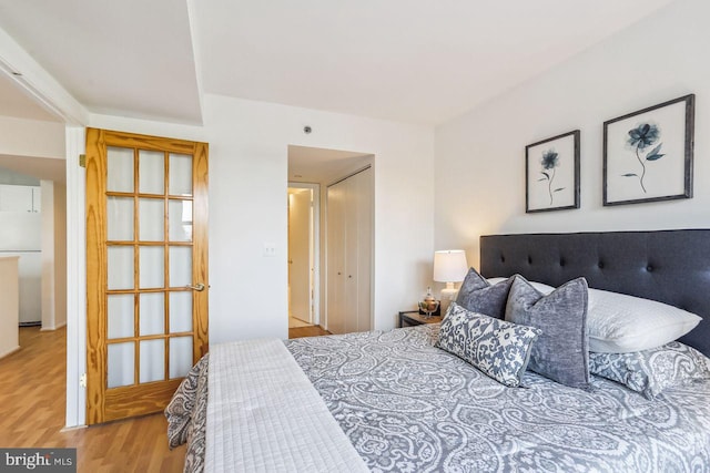 1401 17th St NW Unit 610, Washington, DC 20036 - bedroom with wood finished floors, freestanding refrigerator, and a closet
