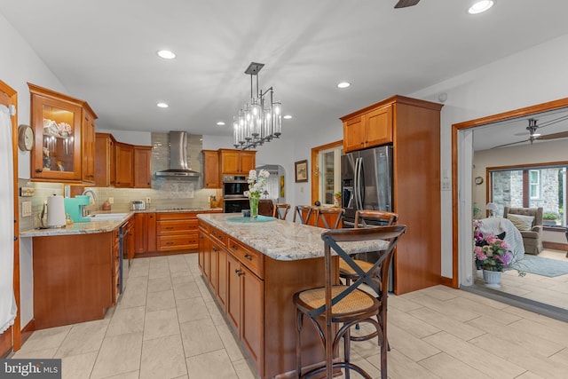 352 Concord Rd, Glen Mills, PA 19342 - kitchen with wall chimney exhaust hood, ceiling fan, appliances with stainless steel finishes, a kitchen island, and recessed lighting