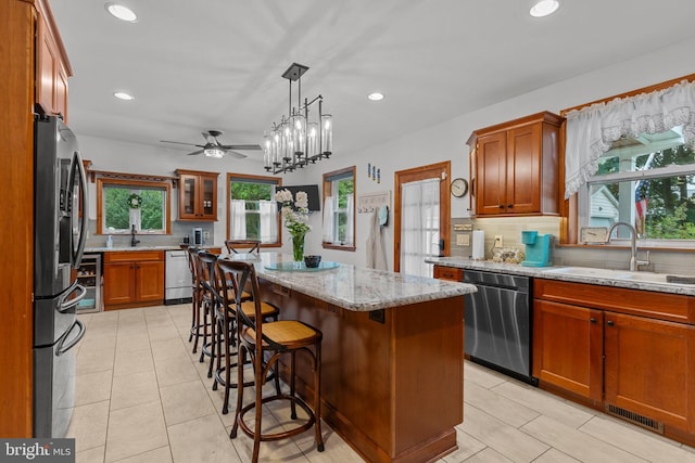 352 Concord Rd, Glen Mills, PA 19342 - kitchen with appliances with stainless steel finishes, backsplash, brown cabinets, a kitchen island, and recessed lighting