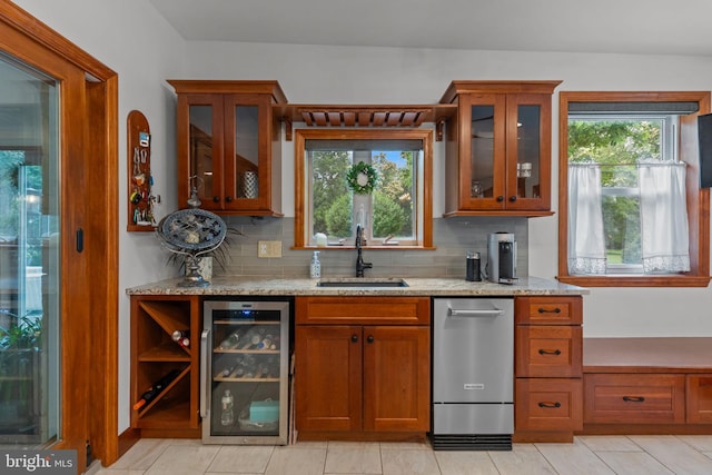 352 Concord Rd, Glen Mills, PA 19342 - kitchen featuring beverage cooler, decorative backsplash, light stone counters, and brown cabinets