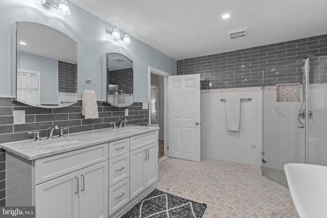 352 Concord Rd, Glen Mills, PA 19342 - full bathroom featuring tile walls, double vanity, tiled shower, and a freestanding bath