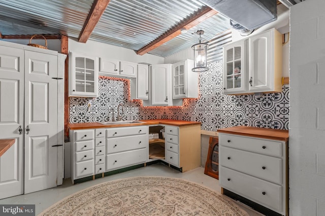 352 Concord Rd, Glen Mills, PA 19342 - kitchen with wood counters, concrete floors, built in desk, white cabinetry, and decorative light fixtures