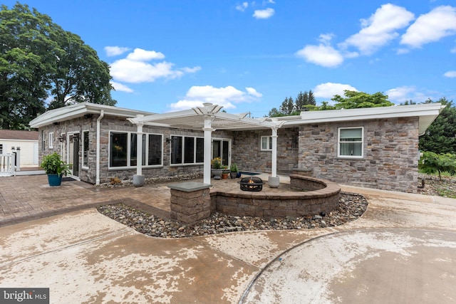 352 Concord Rd, Glen Mills, PA 19342 - rear view of house with a patio area, stone siding, and an outdoor fire pit