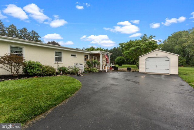 352 Concord Rd, Glen Mills, PA 19342 - view of home's exterior featuring a detached garage, an outdoor structure, a yard, asphalt driveway, and stucco siding