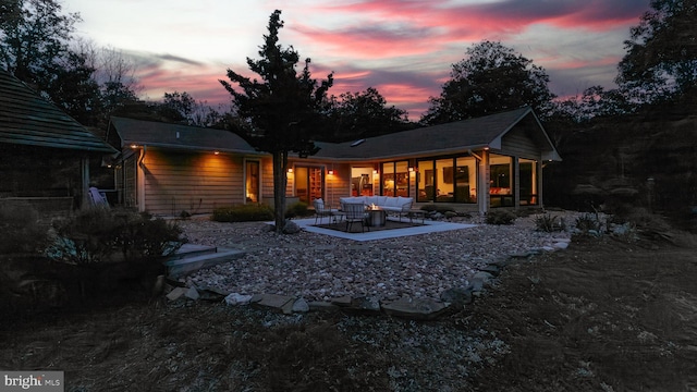 302 Fox Run Rd, Wardensville, WV 26851 - back of property at dusk with an outdoor living space, a patio area, and a sunroom