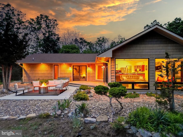 302 Fox Run Rd, Wardensville, WV 26851 - back of house at dusk with an outdoor living space with a fire pit and a patio area