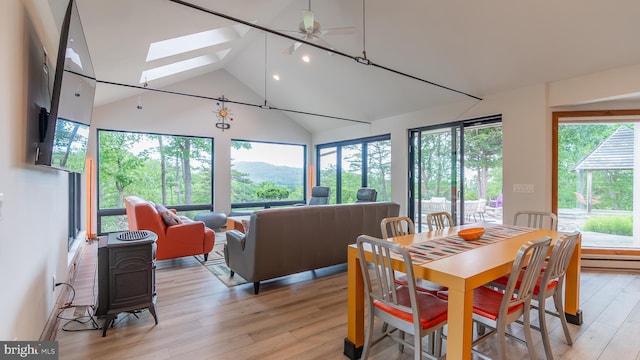 302 Fox Run Rd, Wardensville, WV 26851 - dining space with light wood finished floors, a skylight, high vaulted ceiling, a ceiling fan, and a baseboard heating unit