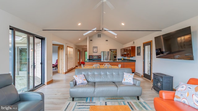 302 Fox Run Rd, Wardensville, WV 26851 - living area featuring ceiling fan, a wood stove, light wood-style flooring, lofted ceiling, and a baseboard radiator