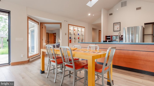 302 Fox Run Rd, Wardensville, WV 26851 - dining area with a baseboard radiator, vaulted ceiling, light wood-type flooring, and a skylight